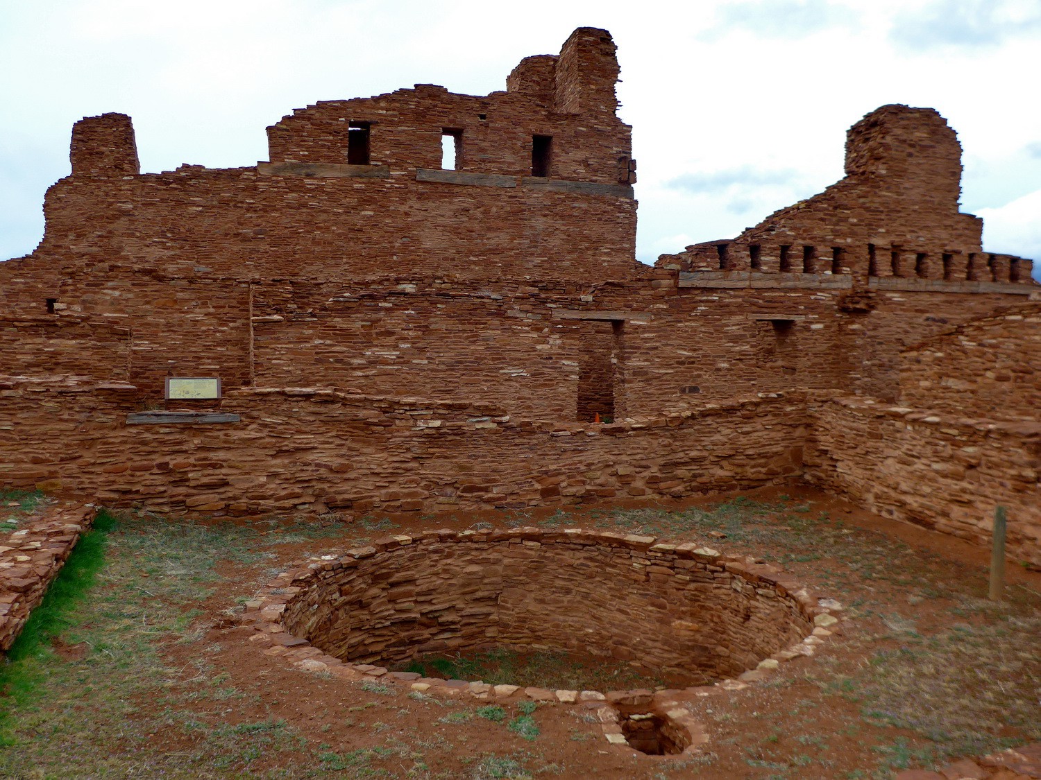 Mission of San Gregorio de Abó with a round Kiva of the Indian people in the foreground